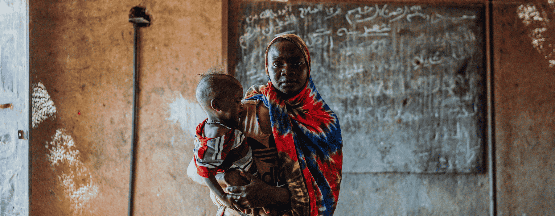 Jongen zit op de grond in vluchtelingenkamp Myanmar
